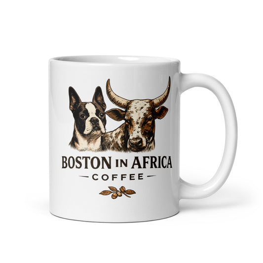White 11 oz glossy ceramic coffee mug with a right-side handle and Boston in Africa Coffee branding.